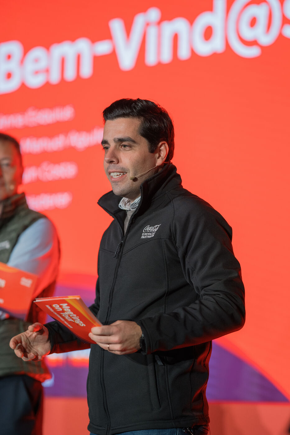 Speaker on stage at the Coca-Cola opening event, corporate photography