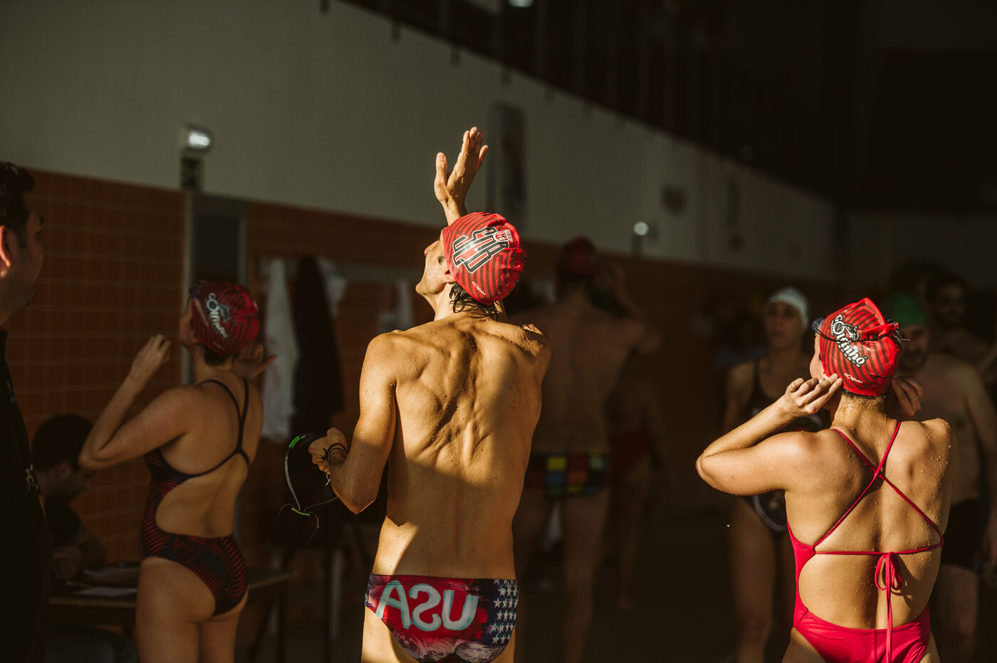 Athletes with caps in the pool lanes at the ANEA Swimming Tournament