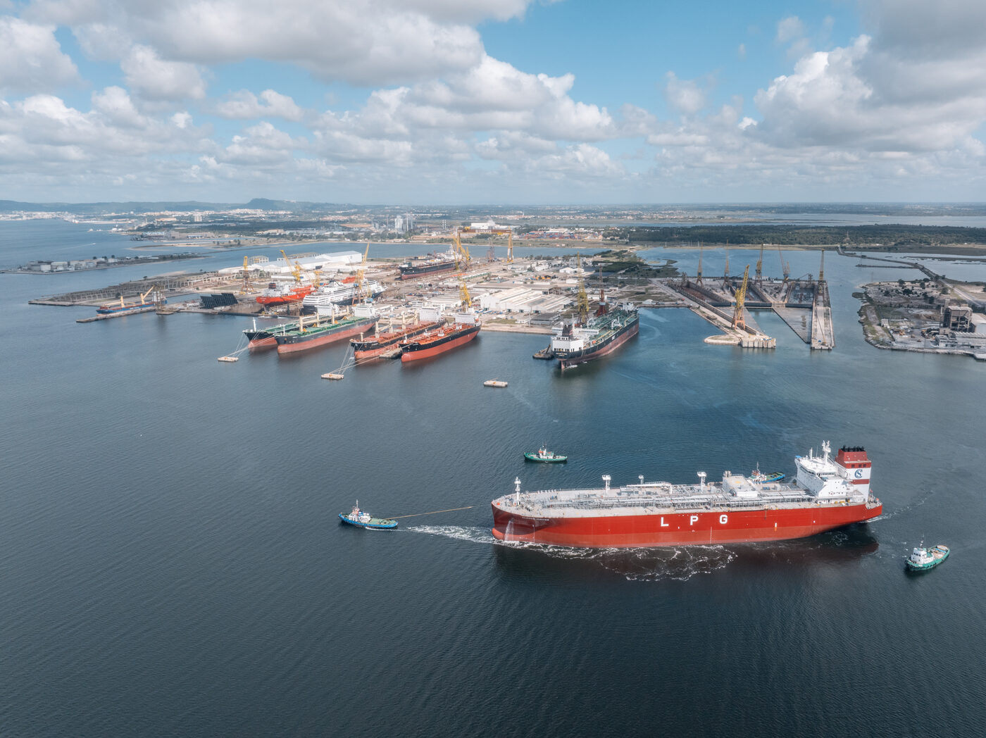 Vista aérea ampla do estaleiro de Setúbal no rio Sado com um navio metaneiro LNG a navegar