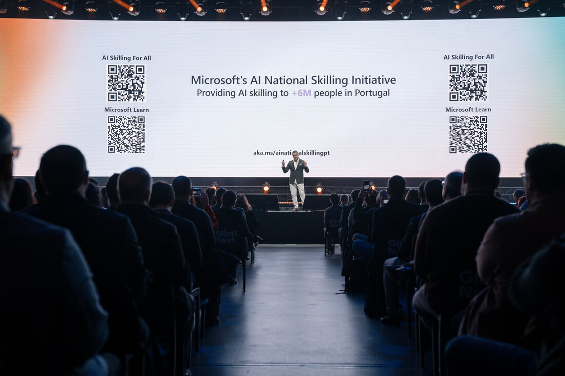 Speaker delivering a keynote on stage at the Microsoft AI Tour in Lisbon, with the screen behind
