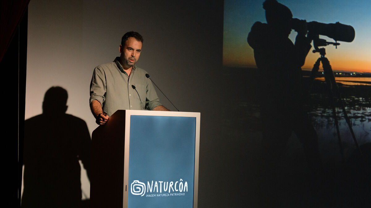 Speaker at the Naturcôa podium with a nature photography projection, Sabugal