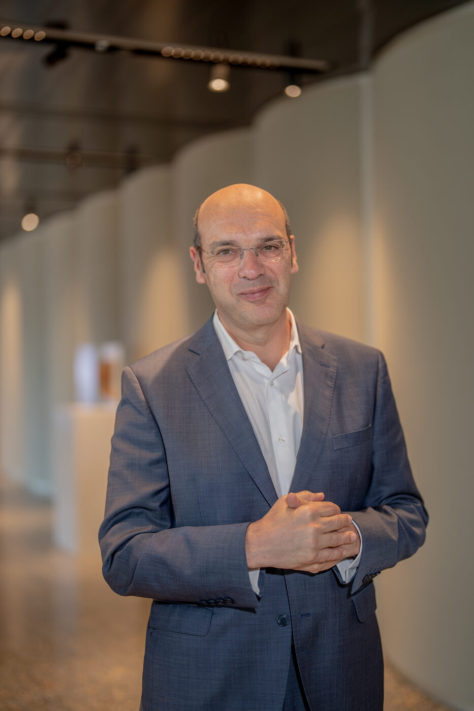 Retrato corporativo de homem de fato em corredor de escritório moderno, fotografia para perfil de empresa