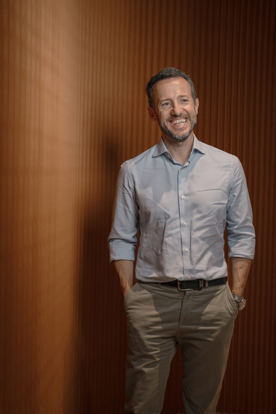 Retrato corporativo de homem encostado a parede de madeira, fotografia para LinkedIn e site