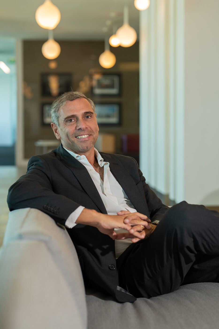 Retrato corporativo descontraído de homem em sofá, fotografia natural para perfil profissional