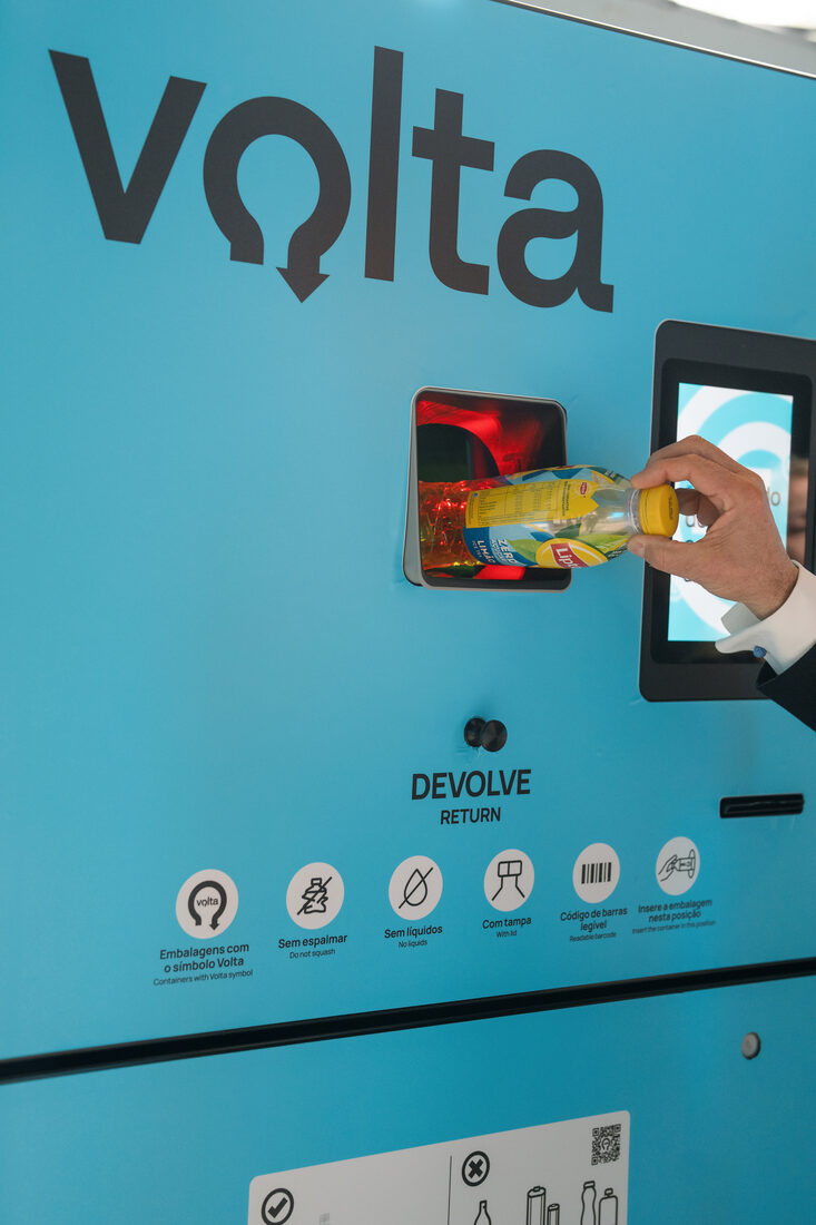 Detalhe de uma máquina de depósito Volta com mão a inserir uma embalagem
